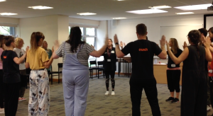 Group of adults in a circle clapping hands